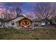 Expansive backyard featuring a covered stone patio with a fire pit, outdoor seating, and a lush lawn at 26 Wedge Way, Littleton, CO 80123