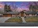 Charming stucco home with a tile roof, a two-car garage, manicured landscaping, and a stone porch at 26 Wedge Way, Littleton, CO 80123
