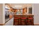 Elegant kitchen with custom wood cabinetry, stainless steel appliances, and stylish breakfast bar seating at 26 Wedge Way, Littleton, CO 80123