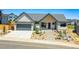 Charming single-story home with a well-manicured yard, modern architecture, and a gray two car garage door at 1148 Hillside Ln, Louisville, CO 80027