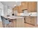 Modern kitchen with an island with seating, stainless steel appliances, and light wood cabinets at 1148 Hillside Ln, Louisville, CO 80027