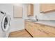 Well-equipped laundry room with modern washer, dryer, cabinetry, and laminate flooring at 1148 Hillside Ln, Louisville, CO 80027