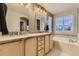 Bright bathroom featuring a double vanity with granite counters, a soaking tub, and tile accents at 3120 Redhaven Way, Highlands Ranch, CO 80126