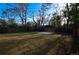Well-sized backyard with a concrete patio, a full privacy fence, and mature trees in a partially shaded yard at 2211 Quebec St, Denver, CO 80207