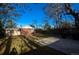 Spacious backyard featuring a brick house, mature trees, a concrete patio, and full fencing at 2211 Quebec St, Denver, CO 80207