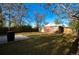 Large backyard with a concrete slab, mature trees, and a privacy fence offering ample outdoor space at 2211 Quebec St, Denver, CO 80207