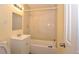 Tiled bathroom featuring a shower-tub combo with cream walls and neutral tile at 2211 Quebec St, Denver, CO 80207