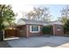 Charming brick home features a carport, well-maintained landscaping, and a spacious driveway at 2211 Quebec St, Denver, CO 80207