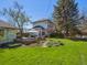 Lovely backyard featuring a fire pit, outdoor kitchen, large grassy area and mature trees at 5801 W 33Rd Ave, Wheat Ridge, CO 80212