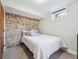 Cozy basement bedroom featuring carpeted floors, brick accent wall, and a bright window at 5801 W 33Rd Ave, Wheat Ridge, CO 80212