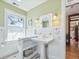 Bright bathroom featuring a pedestal sink, white wainscoting, and views of exterior greenery at 5801 W 33Rd Ave, Wheat Ridge, CO 80212