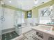 Well lit bathroom features glass enclosed shower, soaking tub, tile flooring and double paned windows at 5801 W 33Rd Ave, Wheat Ridge, CO 80212