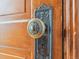 Vintage ornate doorknob and backplate on a wooden door, showcasing intricate design details at 5801 W 33Rd Ave, Wheat Ridge, CO 80212