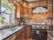 Kitchen features stainless steel appliances, wood cabinets and exposed brick backsplash at 5801 W 33Rd Ave, Wheat Ridge, CO 80212