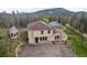 Majestic aerial view of a sprawling home set against a backdrop of mountains and lush trees at 27987 Pine Grove Trl, Conifer, CO 80433