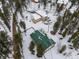 Aerial view of a large lot with home, barn, greenhouse and circular driveway at 27987 Pine Grove Trl, Conifer, CO 80433