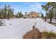 Expansive snowy backyard with a charming wooden fence and a view of a home featuring a cozy outdoor deck at 27987 Pine Grove Trl, Conifer, CO 80433