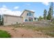 Two-story home featuring a brick-terraced backyard and large windows overlooking a treed lawn at 27987 Pine Grove Trl, Conifer, CO 80433