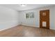 An empty bedroom with a wood laminate floor, a window, and a wood door at 27987 Pine Grove Trl, Conifer, CO 80433