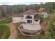 Two-story house with a large arched window, patio, and well-kept retaining wall with a garden at 27987 Pine Grove Trl, Conifer, CO 80433