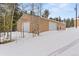 Spacious two-car garage offers ample parking and storage in a snowy, wooded setting at 27987 Pine Grove Trl, Conifer, CO 80433
