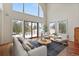 Bright living room featuring large windows with views, a comfortable sofa, and a stylish area rug at 27987 Pine Grove Trl, Conifer, CO 80433