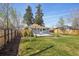 Well-maintained backyard with green grass, wooden fence, and cozy deck space at 4290 S Cherokee St, Englewood, CO 80110