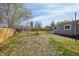 Large backyard with grass, dirt patches, perimeter fencing and a shed at 4290 S Cherokee St, Englewood, CO 80110