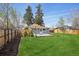 Well-maintained backyard with green grass, wooden fence, and cozy deck space at 4290 S Cherokee St, Englewood, CO 80110
