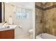 Cozy bathroom featuring tile shower/tub, vanity sink, and soft natural light at 4290 S Cherokee St, Englewood, CO 80110
