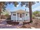 Charming cottage-style home with a red front door, stone walkway, and lush landscaping at 4290 S Cherokee St, Englewood, CO 80110