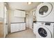 Well-equipped laundry featuring a stacked washer, dryer, and storage cabinets at 4290 S Cherokee St, Englewood, CO 80110