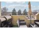 Outdoor deck with grill, patio furniture, and lovely treeline view at 1818 S Quebec Way # 11-3, Denver, CO 80231