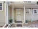 A covered front porch featuring white columns, storm door, small garden, and 'welcome' doormat at 1818 S Quebec Way # 11-3, Denver, CO 80231
