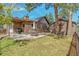 Spacious backyard featuring a charming house with a patio and a well-maintained lawn at 23039 Isoleta Rd, Indian Hills, CO 80454