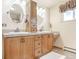 Full bathroom with vanity and framed mirrors, drawers, a bathtub with glass door, and a bright window at 23039 Isoleta Rd, Indian Hills, CO 80454