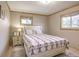 Comfortable carpeted bedroom with a queen-size bed, nightstand and natural lighting through the windows at 23039 Isoleta Rd, Indian Hills, CO 80454