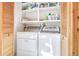 Bright laundry area with appliances and shelving for ample storage space and convenience at 23039 Isoleta Rd, Indian Hills, CO 80454