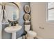 Stylish powder room featuring a pedestal sink, modern fixtures, and decorative wall art at 13333 Blue Amber Ct, Parker, CO 80134