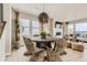 Elegant dining room featuring a round wooden table, wicker chairs, and natural light from large windows at 13333 Blue Amber Ct, Parker, CO 80134
