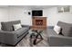 Finished basement with gray couches, glass-top table, brick fireplace, and luxury vinyl plank flooring at 1852 S Elm St, Denver, CO 80222