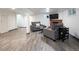 Finished basement with gray couches, brick fireplace, and luxury vinyl plank flooring at 1852 S Elm St, Denver, CO 80222