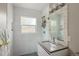 Bright bathroom featuring white tile, a stone framed mirror and a sleek vanity at 1852 S Elm St, Denver, CO 80222