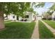 Bungalow exterior with detached garage, long driveway, and mature trees in a green lawn at 1852 S Elm St, Denver, CO 80222