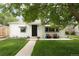 Charming white bungalow with a neatly maintained front yard and inviting porch seating at 1852 S Elm St, Denver, CO 80222