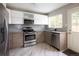 Modern kitchen with stainless steel appliances, stylish cabinetry, and natural light from a window at 1852 S Elm St, Denver, CO 80222