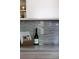 Close up of kitchen counter with grey backsplash, wine bottle and cookbook at 1852 S Elm St, Denver, CO 80222