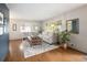 Sunlit living room with hardwood floors, neutral furniture, and large windows overlooking the yard at 1852 S Elm St, Denver, CO 80222