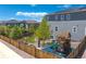 View of a fenced backyard with a playground, lush lawn, and well-maintained landscaping at 1114 Basalt Ridge Loop, Castle Rock, CO 80108