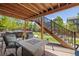 Under-deck patio area with outdoor seating, a fire table, and views of the landscaped backyard at 1114 Basalt Ridge Loop, Castle Rock, CO 80108